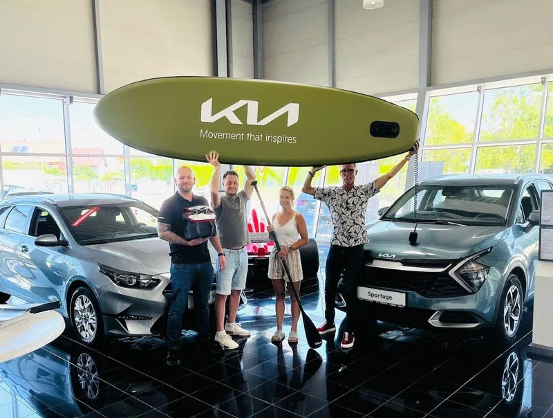 Gruppe mit Kia Tafel im Schauraum von KFZ Miltner
